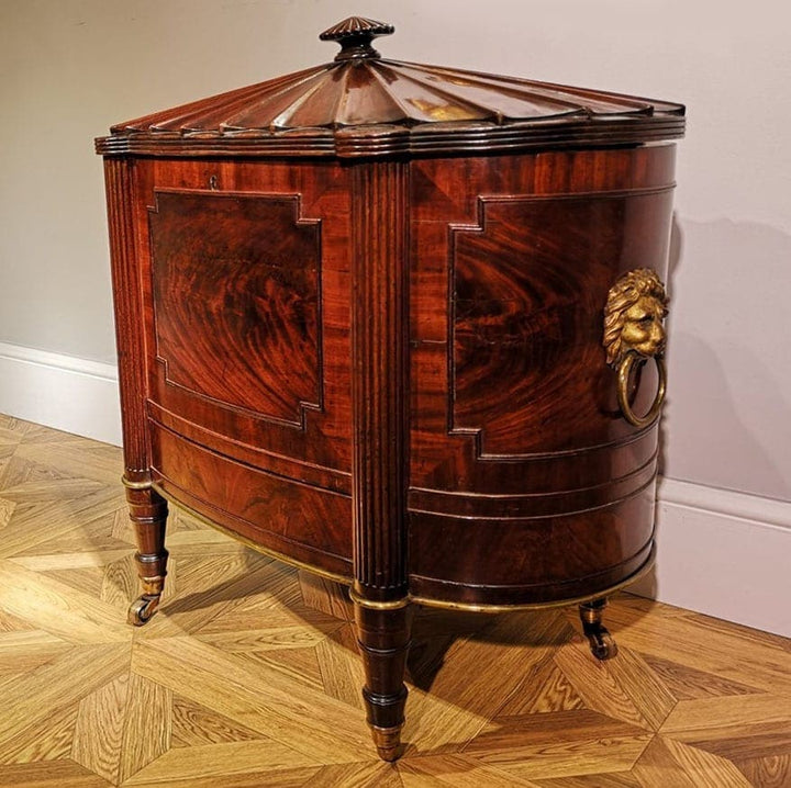 George III Cellarette Attributed To Gillows, oval mahogany cabinet with brass lion handles and tapered reeded legs on casters