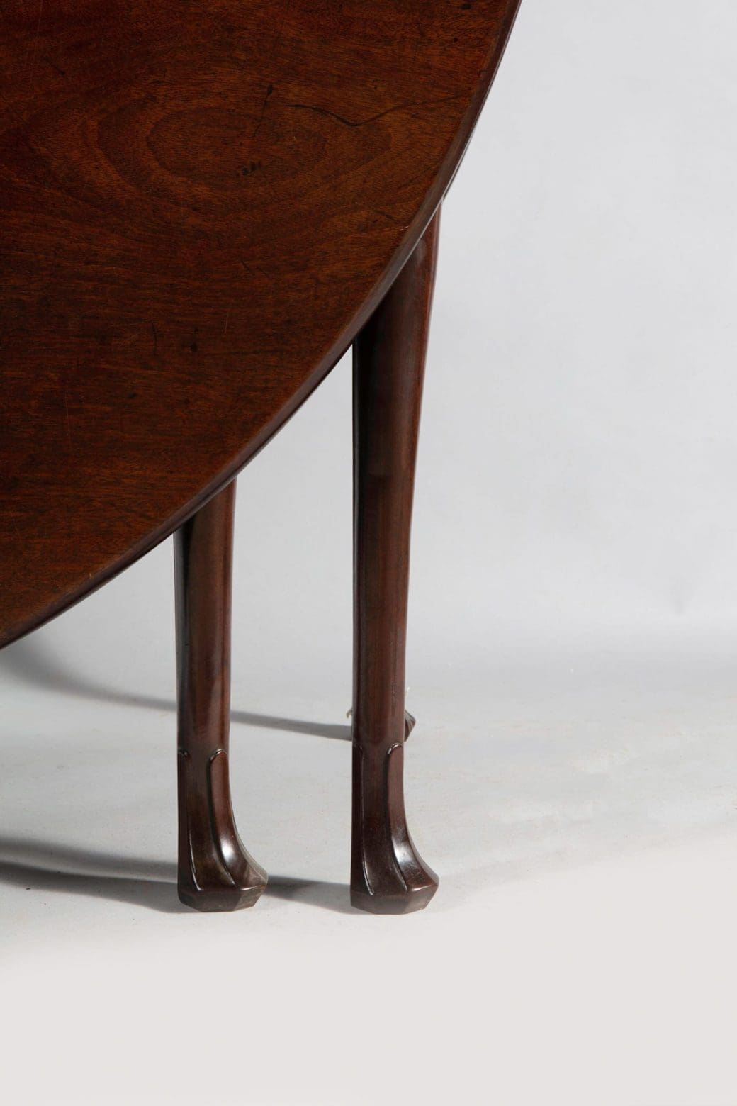 Irish George II mahogany oval drop leaf table showing cabriole legs with fluted pad feet.