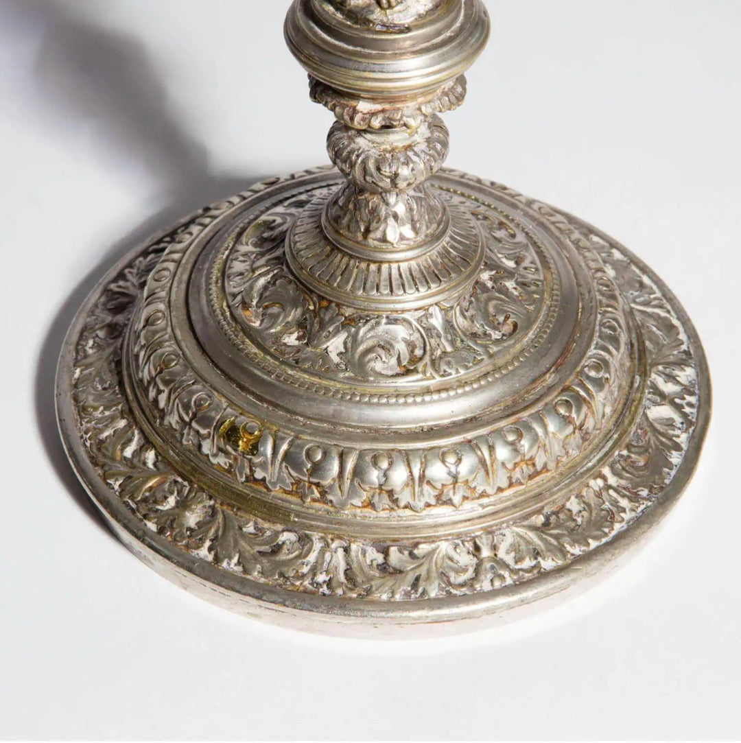 Pair of Silvered Putti Table Lamps with ornate silver plated circular bases featuring leaf and cherub designs.