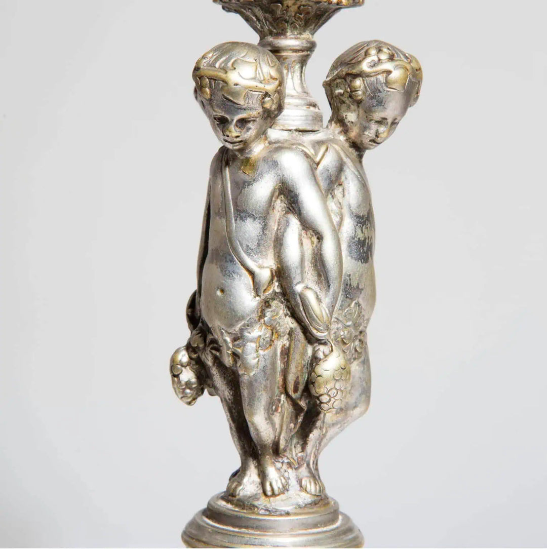Pair of Silvered Putti Table Lamps with three cherubic figures on silver plated Renaissance Revival candlesticks.