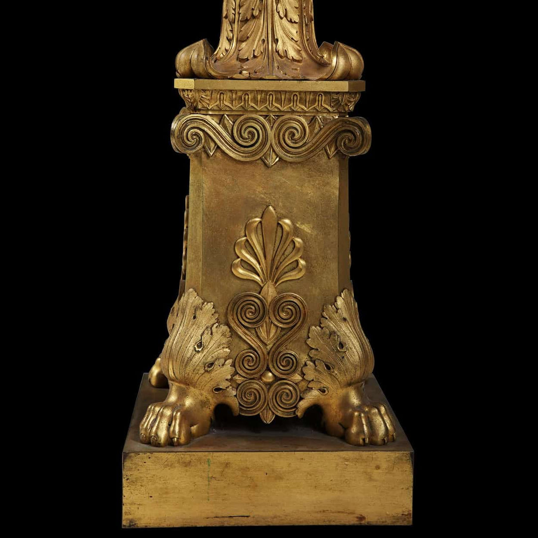 Empire Gilt Bronze Torchere Candle Stand with fluted column, foliate capital, and hairy paw feet base in gilt bronze.