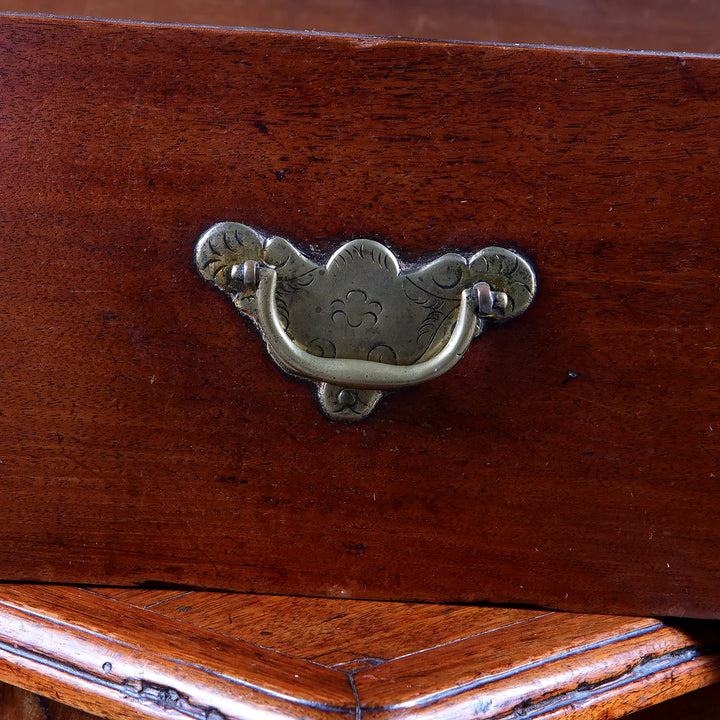 Close-up of brass drop handle on George I Pedestal Chest of Drawers made of early 18th century mahogany wood.