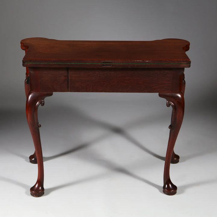 George II Mahogany Card Table with shaped top, cabriole legs, acanthus details, and elegant pad feet circa 1735 England.