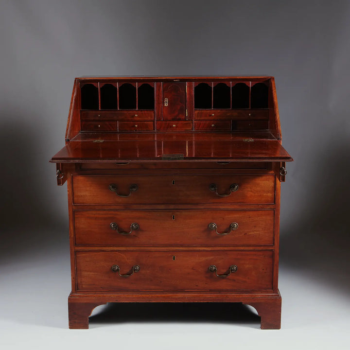 George III Bureau Desk Chest of Drawers, mid 18th century, with fall front, pigeon holes, drawers, and bracket feet in grained timber.