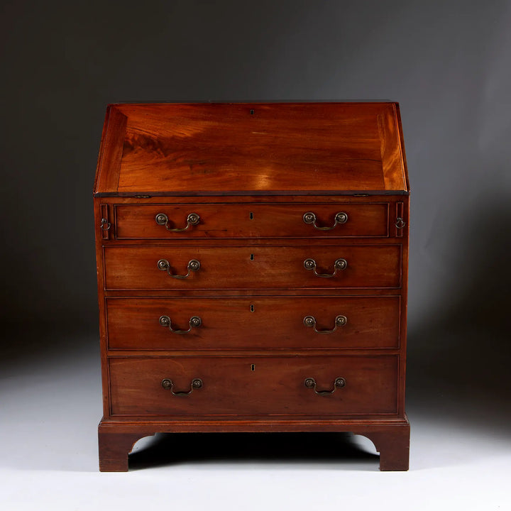 George III Bureau Desk Chest of Drawers in rich wood with fall front, four drawers, and bracket feet, circa 1740 England.