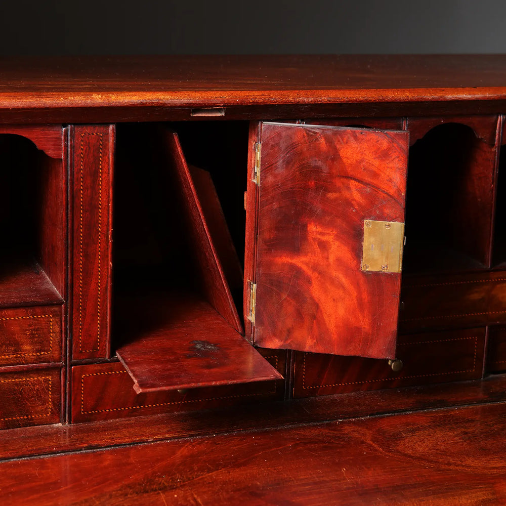 George III Bureau Desk Chest of Drawers with fall front, pigeon holes, drawers, and hidden compartments in grained timber.
