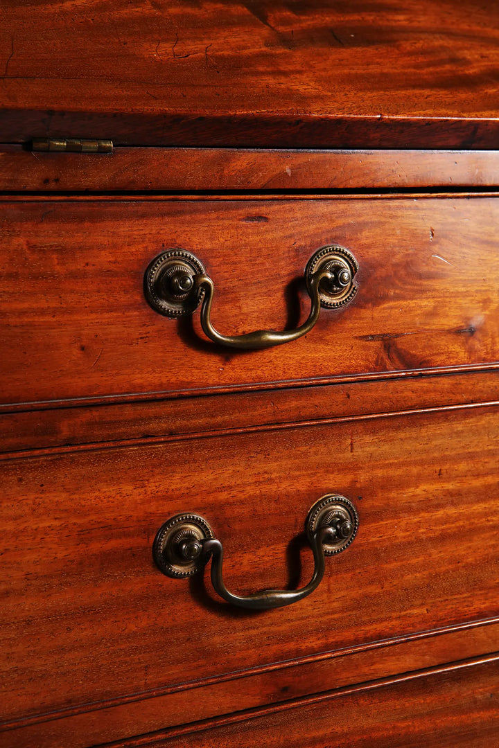 George III Bureau Desk Chest of Drawers with brass drop handles and rich grained wood finish in mid-18th century style.