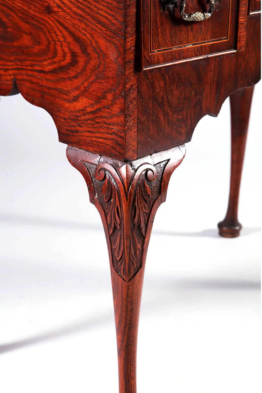 GEORGE II OAK LOW BOY with carved cabriole leg and sculptural foliate detailing on oak wood.