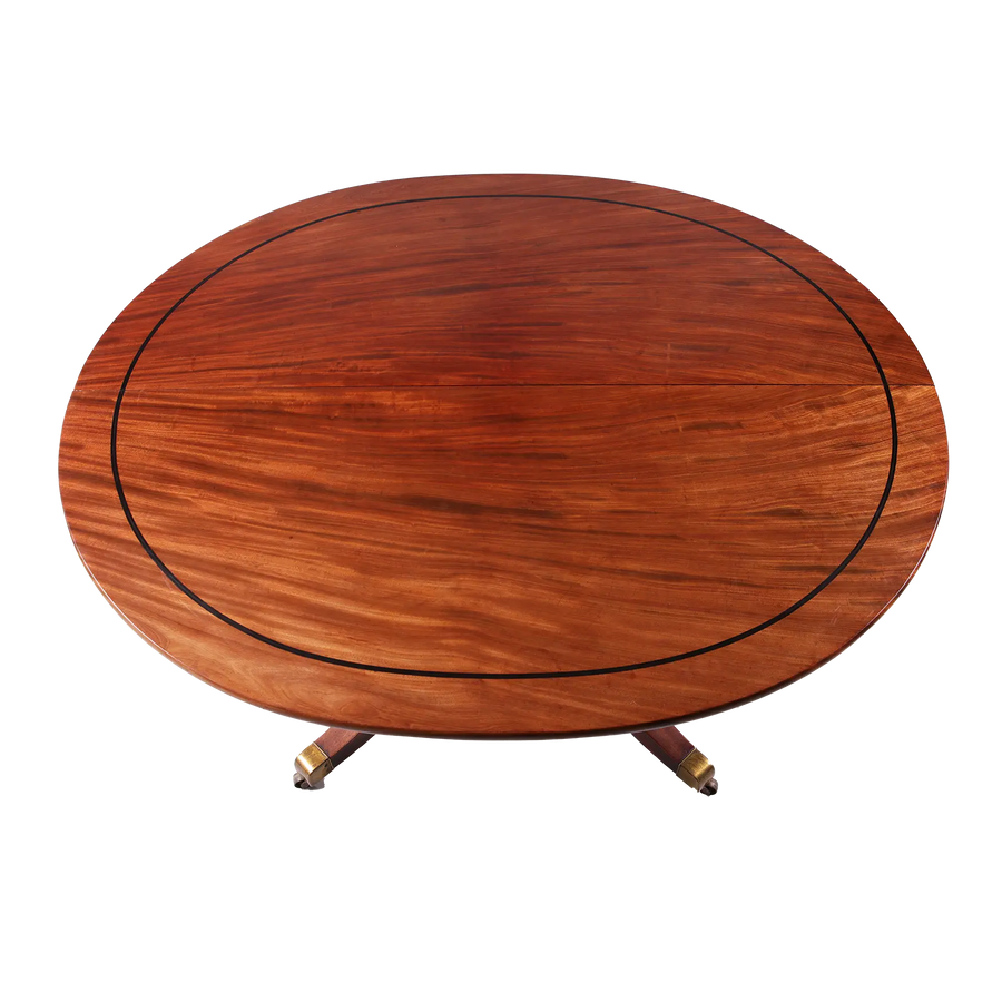 Extending Oval Dining Table in the Manner of George Bullock with mahogany top and ebony stringing on pedestal base.