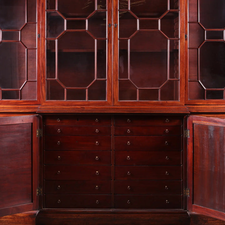 GEORGE III MAHOGANY BREAKFRONT BOOKCASE with glazed doors and multiple drawers in rich mid-18th century mahogany wood.