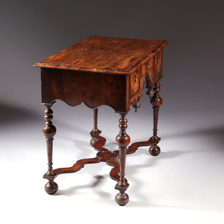 GEORGE I WALNUT LOW BOY with rectangular top, Dutch gable aprons, lathe turned legs, X stretcher, and bun feet circa 1700.