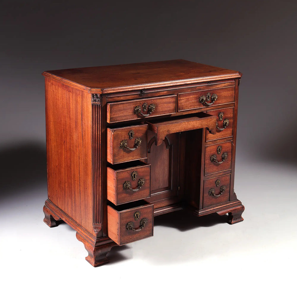 GEORGE II MAHOGANY KNEEHOLE DESK early 18th century with brass handles and ogee bracket feet, England circa 1725