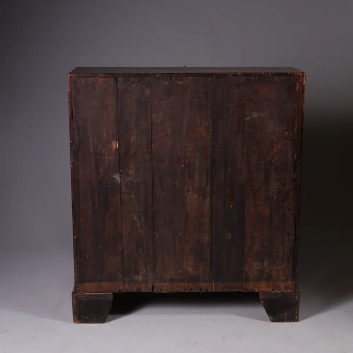 GEORGE I BURR WALNUT BUREAU CHEST showing aged wood back panel and solid block feet in dark finish