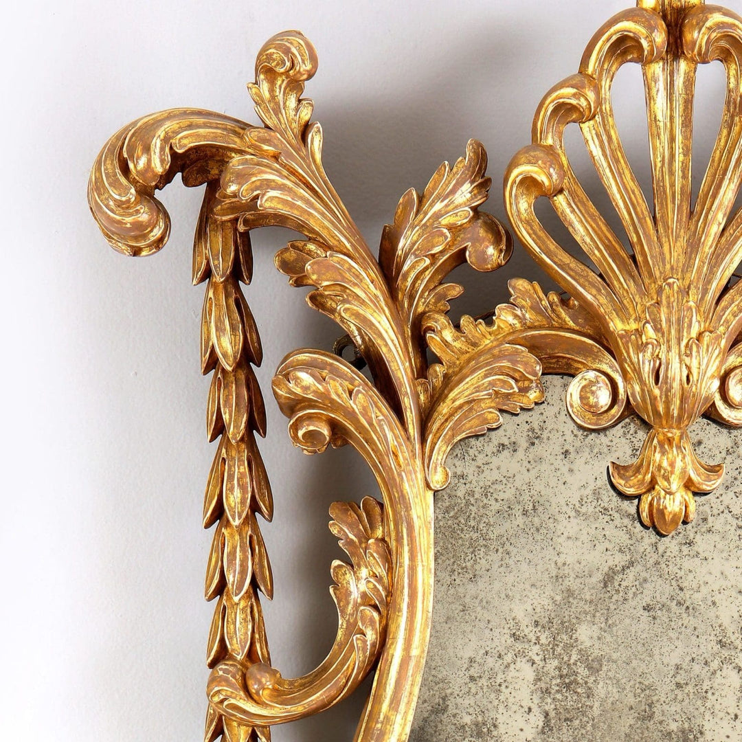 Georgian giltwood girandole mirror with carved anthemion, acanthus leaves, and antique mirror plate detail.