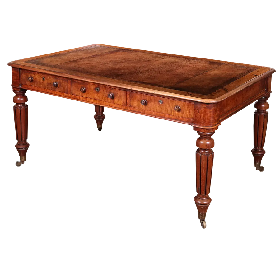 Regency Fiddleback Mahogany Partners Writing Table with tooled leather top, turned legs, brass castors, and drawers circa 1815.