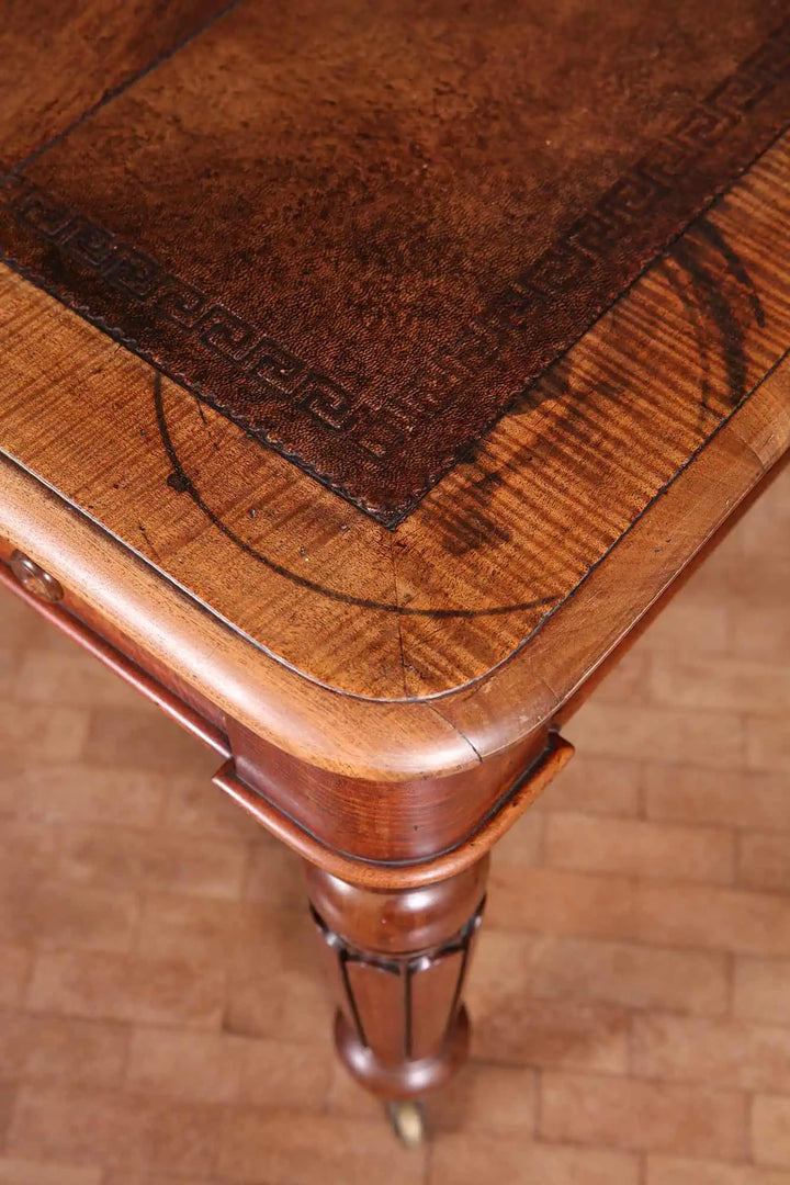 Regency Fiddleback Mahogany Partners Writing Table corner detail showing tooled leather top and carved leg on brass castor.