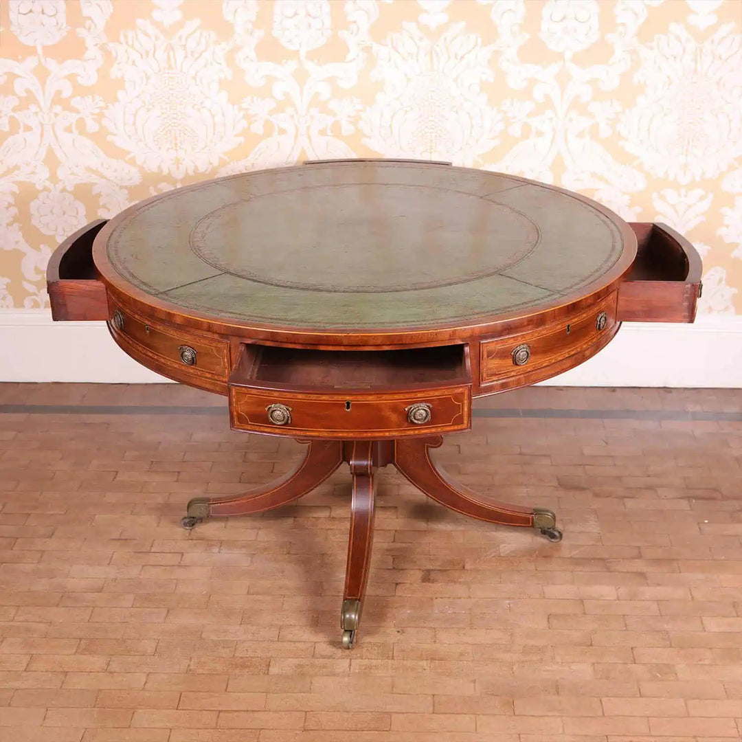 Sheraton Mahogany Drum Table with tooled leather top, eight drawer fronts, pedestal base, and brass castors circa 1815.