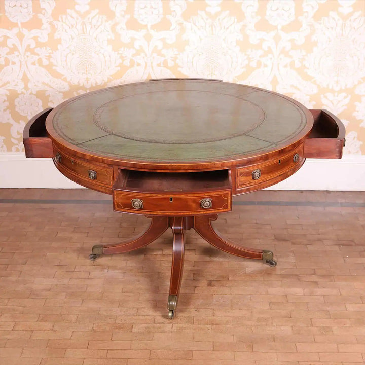 Sheraton Mahogany Drum Table with tooled leather top, eight drawer fronts, pedestal base, and brass castors circa 1815.