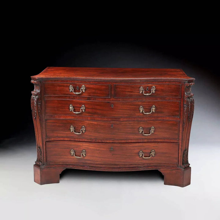 AN IMPORTANT GEORGE III MAHOGANY COMMODE Attributed to William Gomm with serpentine top and gilt rococo handles.