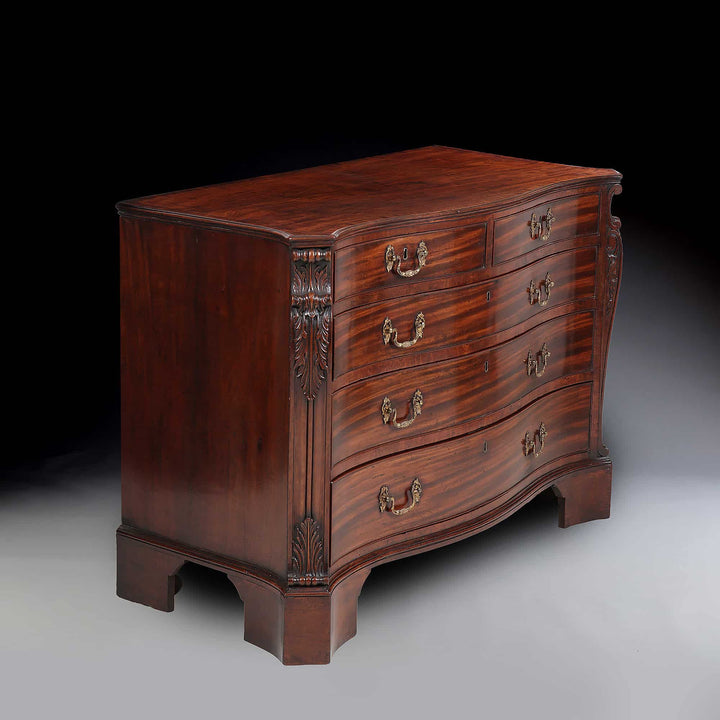 AN IMPORTANT GEORGE III MAHOGANY COMMODE Attributed to William Gomm with serpentine drawers and gilt rococo handles.