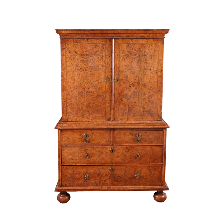 George I Burr Walnut Chest on Chest with bookmatched burr walnut doors and multiple drawers on turned bun feet.