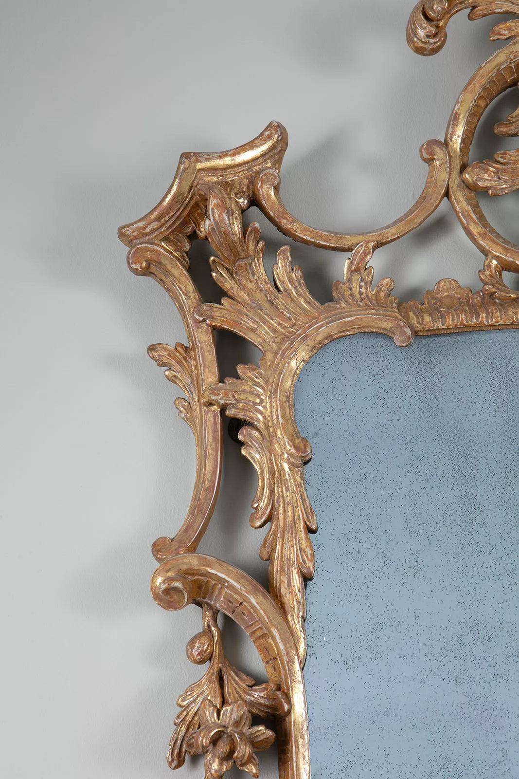 George II Chippendale Giltwood Mirror with intricate carved rococo giltwood detailing and original aged mirror plate.