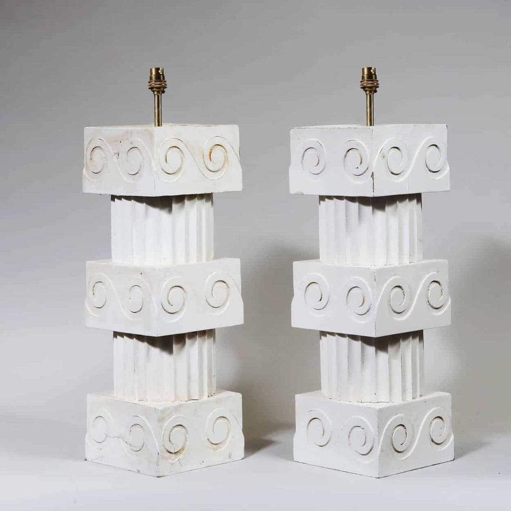 A Pair of Vitruvian Scroll Column Lamps with turned wood, fluted columns, and scroll ornament cubes in white finish.