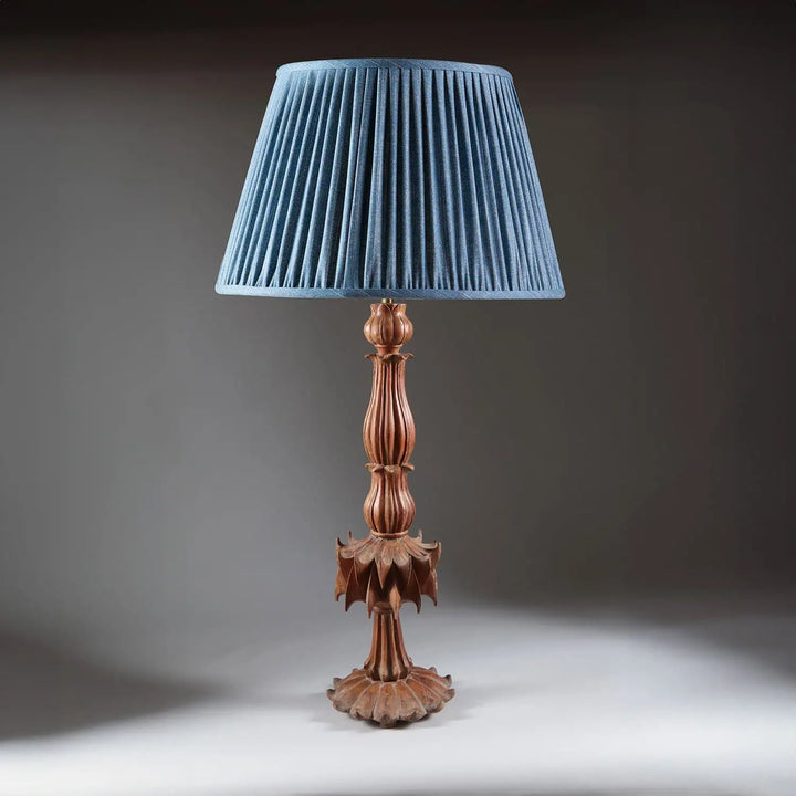 Futuristic Carved Teak Table Lamp with reeded stem, petal base, and blue pleated shade, 19th century Indian design.