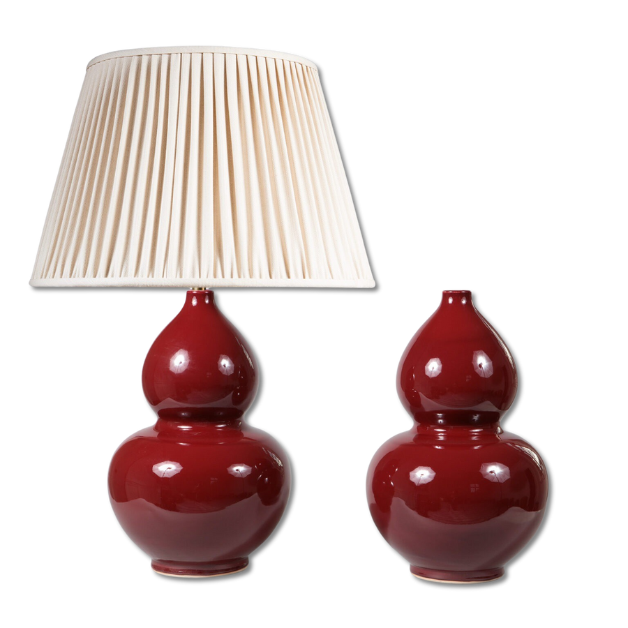 Pair of Sang de Boeuf Double Gourd Vases as Table Lamps in deep red with one fitted with a pleated beige lampshade.