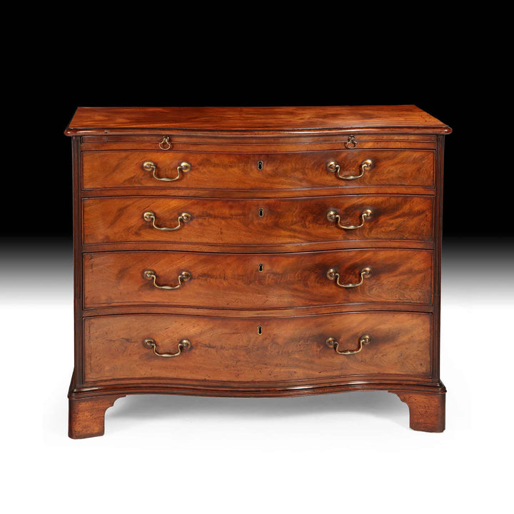 Fine George III Chippendale Chest Of Drawers in 18th century mahogany with original gilt handles and serpentine front.