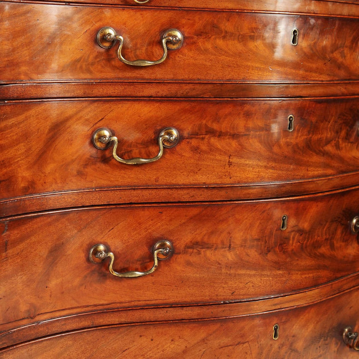 Fine George III Chippendale Chest Of Drawers with flame mahogany veneer and original gilt swan-neck handles.