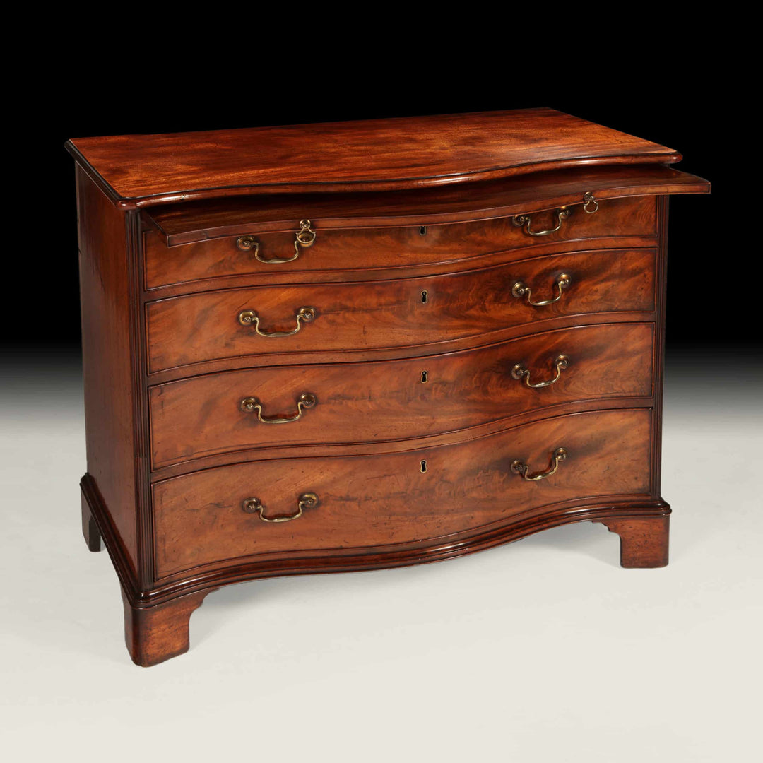 Fine George III Chippendale Chest Of Drawers in mahogany with original gilt handles and serpentine front circa 1760.