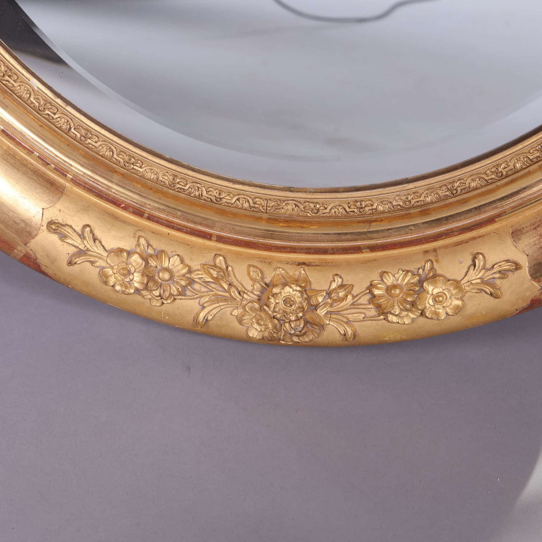 Pair of Victorian Giltwood Oval Wall Mirrors with intricate floral giltwood frame and beveled mercury plates circa 1880 England.