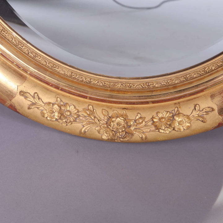 Pair of Victorian Giltwood Oval Wall Mirrors with intricate floral giltwood frame and beveled mercury plates circa 1880 England.