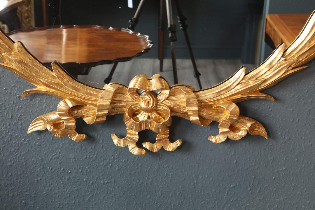 Substantial oval giltwood mirror with ornate carved floral details, 19th Century English design circa 1870.