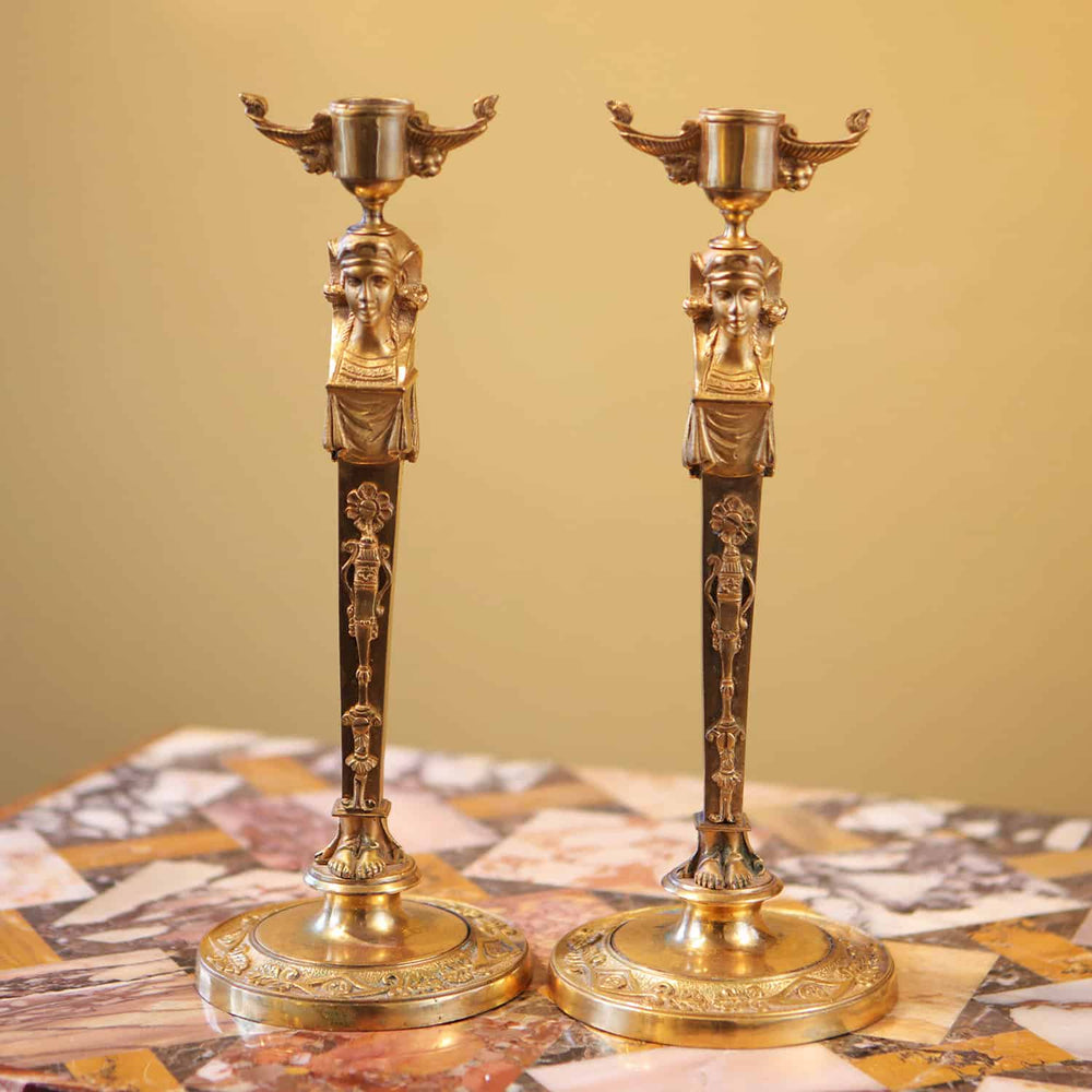 Pair Of Neo Egyptian Empire Gilt Bronze Candlesticks with caryatid figures and lion mask handles, circa 1820, France.