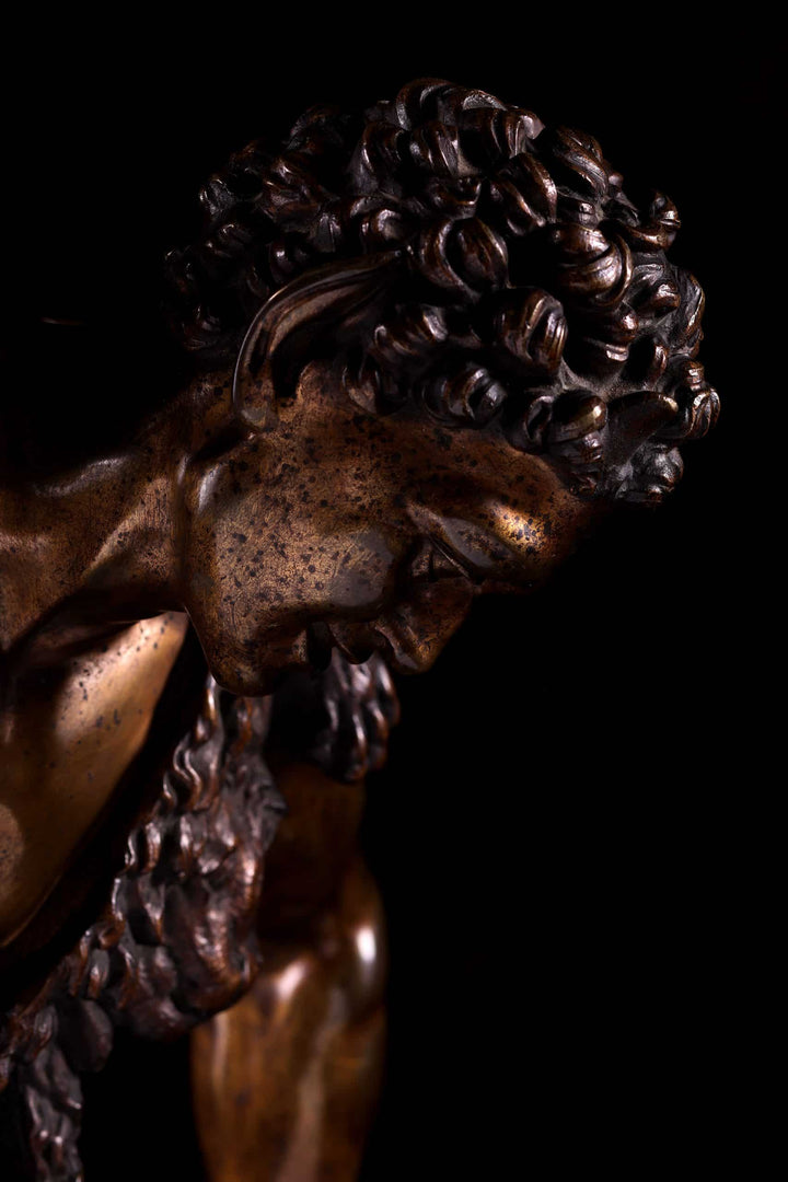 Bacchanalian Bronze Faun after Soldani close-up of antique bronze sculpture with detailed curly hair and facial features