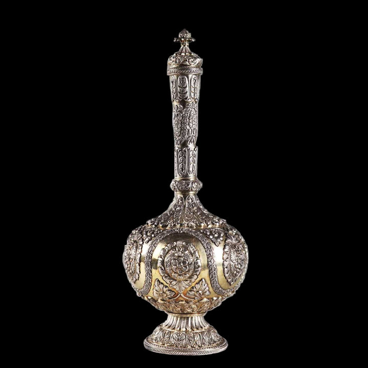 Decorative Indian silver flask with raised intricate patterns on a gilt ground.