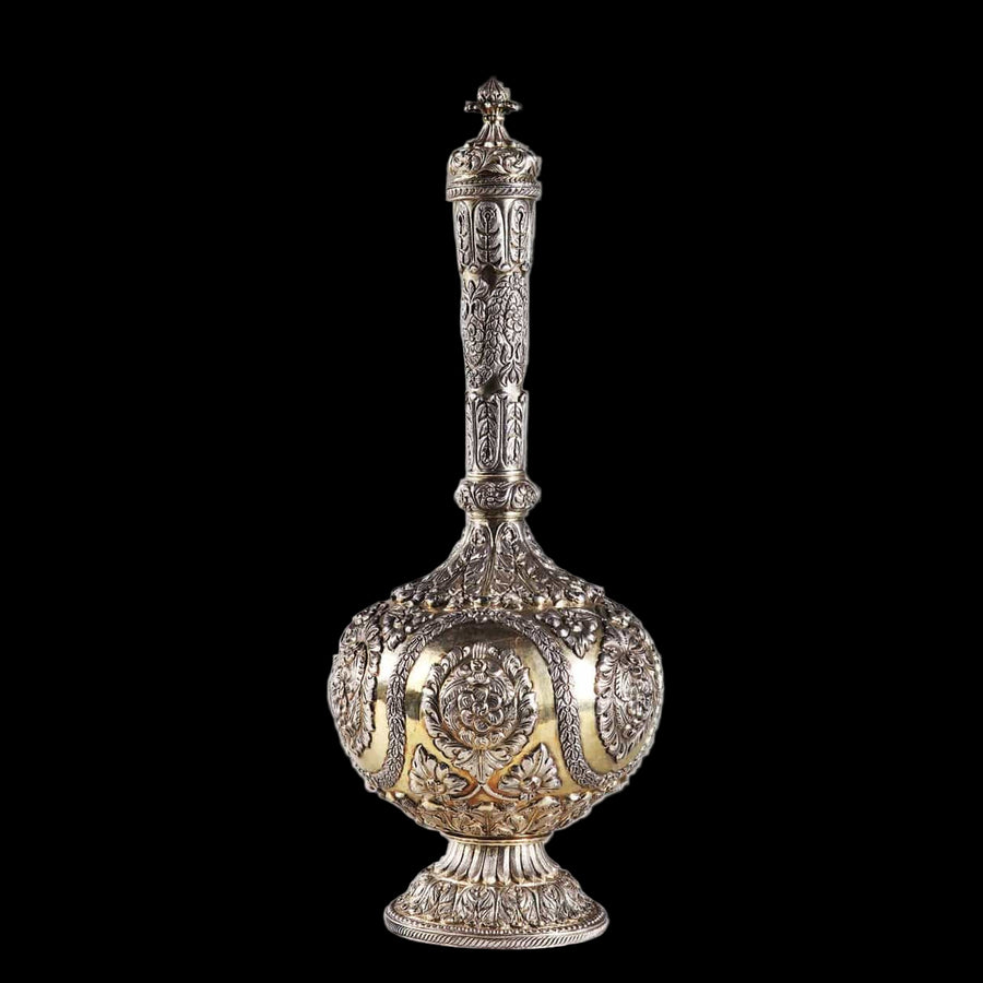 Decorative Indian silver flask with raised intricate patterns on a gilt ground.