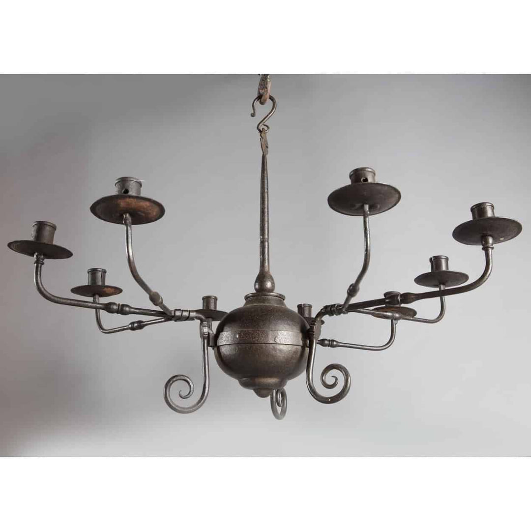 An Arts and Crafts black patinated nine branch Iron chandelier