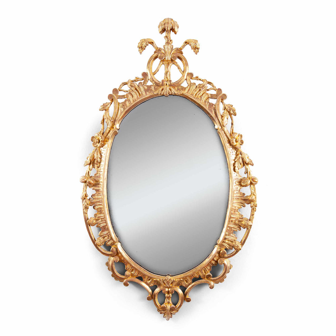 George III Rococo giltwood oval mirror with ornate floral and scroll detailing, English, circa 1770, 81 cm height.