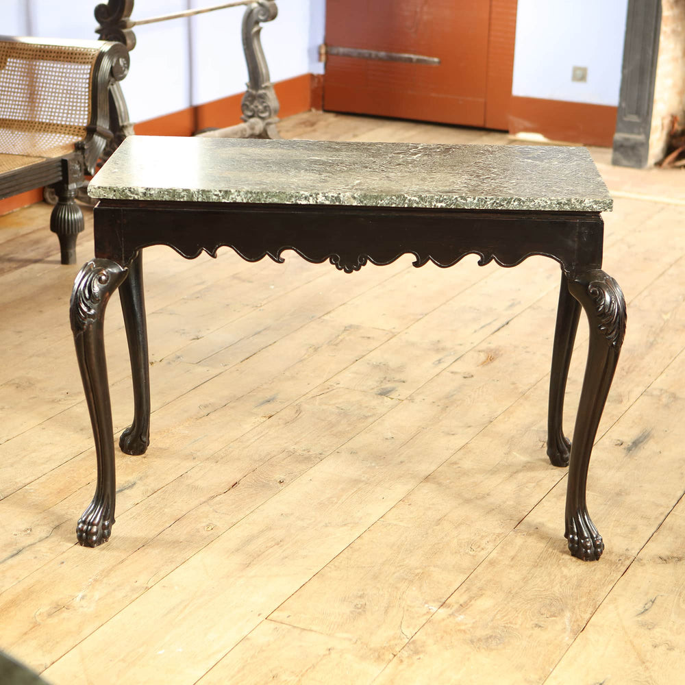 Anglo Indian Ebonised Centre table with green marble top, cabriole legs ending in paw feet, and floral motif apron.