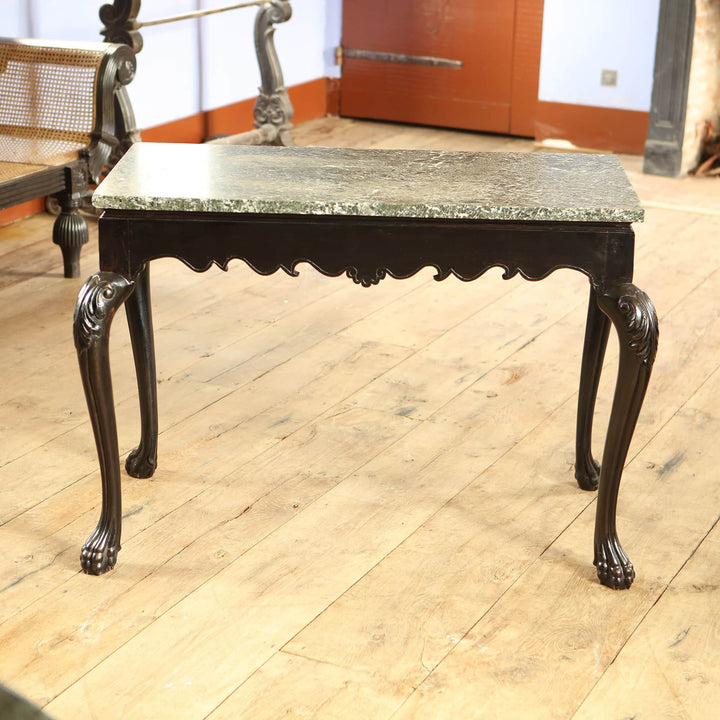 Anglo Indian Ebonised Centre table with green marble top, cabriole legs ending in paw feet, and floral motif apron.