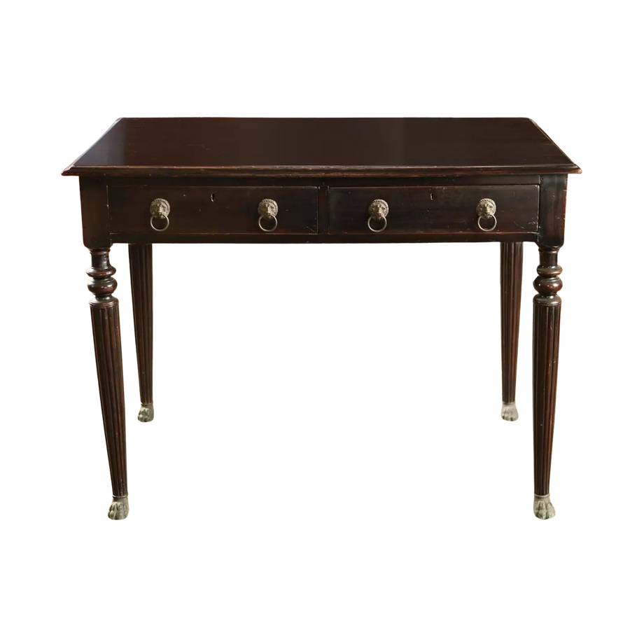 Anglo Indian Ebonised Writing Table with two drawers, fluted legs, lion mask handles, and brass paw feet from 1860.