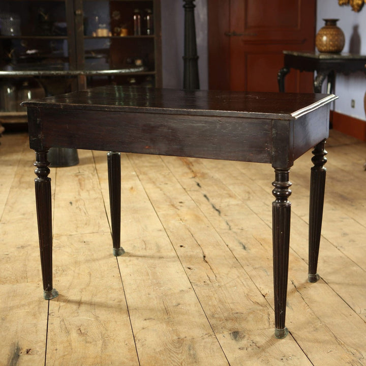 Anglo Indian Ebonised Writing Table with two drawers, lion mask handles, fluted legs, and brass paw feet circa 1860.