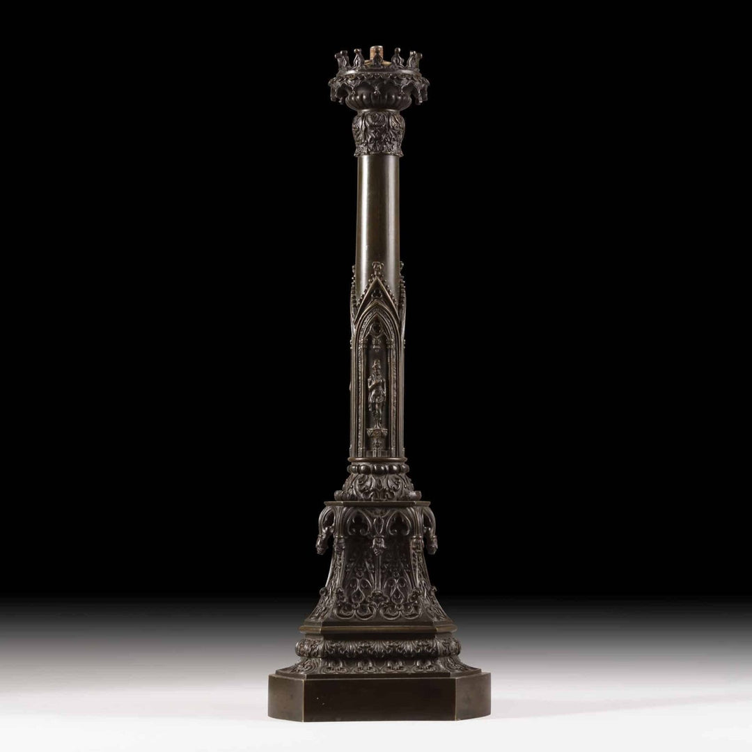 A William IV bronze gothic column lamp with medieval-style figures and detailed crown capital on a triangular plinth.