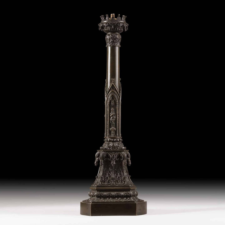 A William IV bronze gothic column lamp with medieval-style figures and detailed crown capital on a triangular plinth.