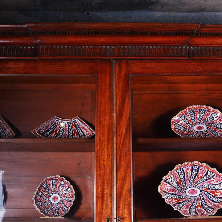 George III Chippendale period mahogany breakfront bookcase with glazed doors and intricate carved details.