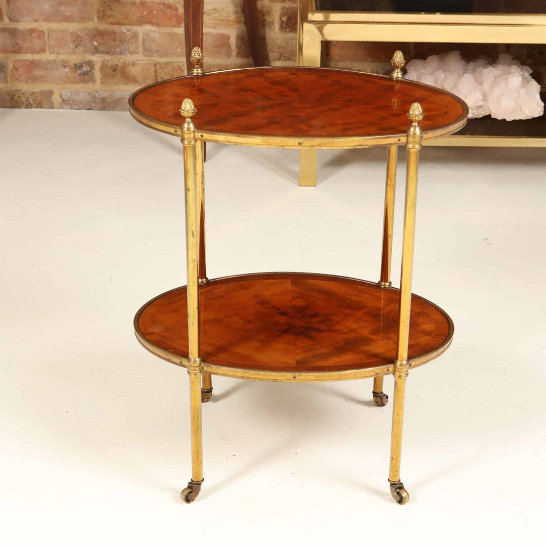 Quarter Veneered Bookmatched Mahogany Oval 2 Tier Table with brass legs and casters, circa 1910 England, elegant antique design.