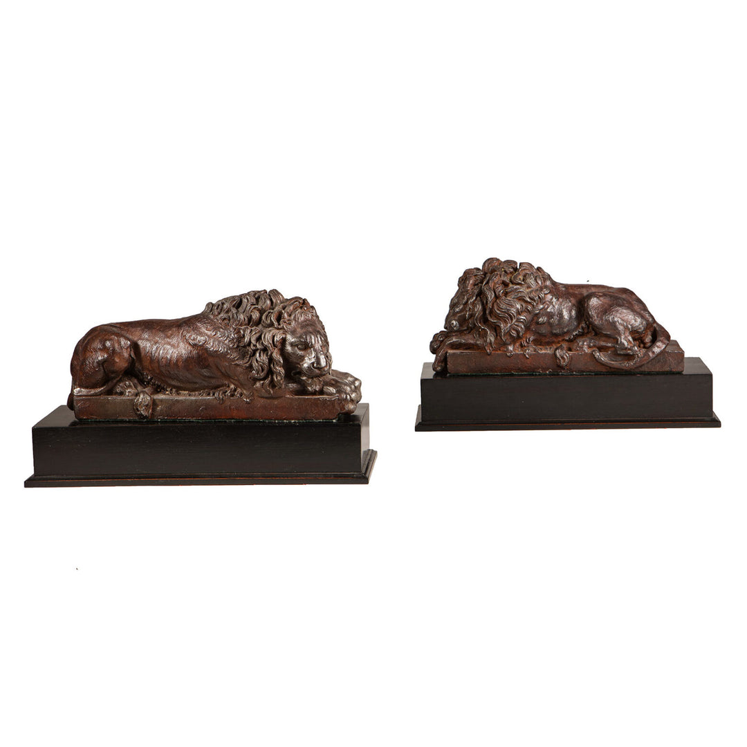 Pair of Cast Iron Versions of the Canova Lions, antique cast iron sculptures of sleeping and vigilant lions on bases.